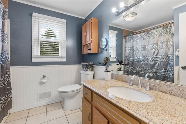 full bathroom featuring a wainscoted wall, tile patterned flooring, toilet, ornamental molding, and vanity