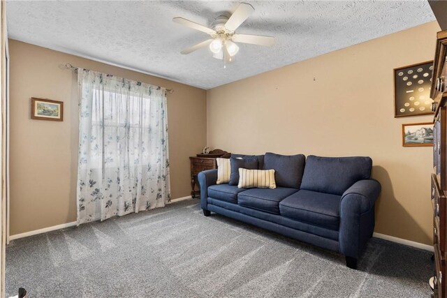carpeted living area with a ceiling fan, a textured ceiling, and baseboards