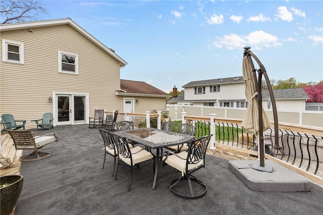 view of patio featuring outdoor dining space, fence, and a deck