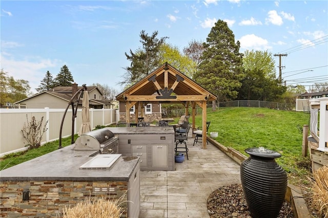 view of patio featuring a gazebo, grilling area, and exterior kitchen