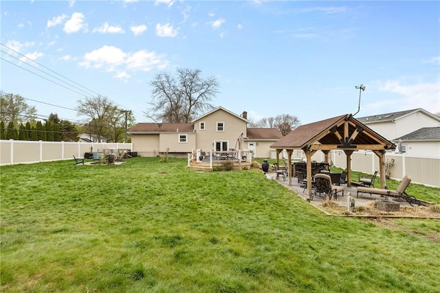 back of property featuring a gazebo, a deck, a patio, and an outdoor fire pit