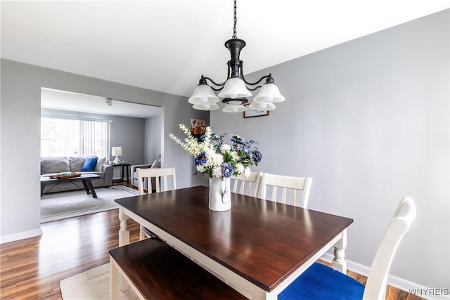 dining room with a chandelier, wood finished floors, and baseboards