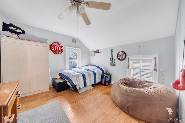 bedroom with vaulted ceiling, light wood-style floors, and ceiling fan