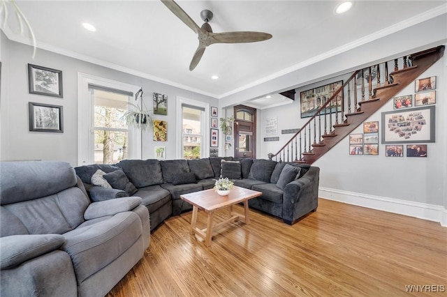 living room featuring light wood-type flooring, stairway, ceiling fan, recessed lighting, and crown molding