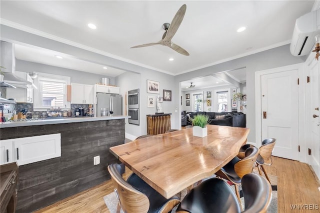 dining space with ceiling fan, light wood-style flooring, an AC wall unit, ornamental molding, and recessed lighting