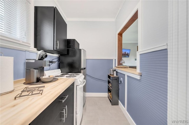kitchen featuring white electric range oven, crown molding, dark cabinets, wooden counters, and baseboards