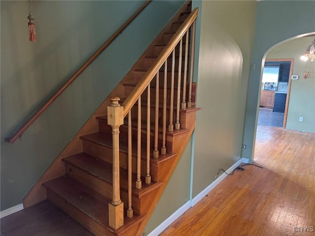 1270 W Belden Ave, Syracuse, NY 13204 - stairs featuring arched walkways, hardwood / wood-style flooring, and baseboards