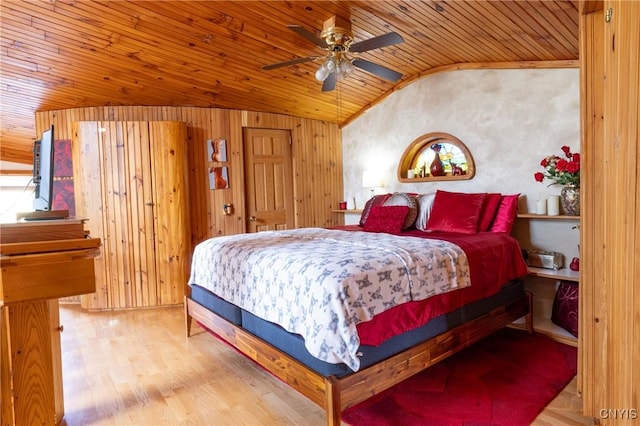 bedroom featuring vaulted ceiling, wood walls, wooden ceiling, and wood finished floors