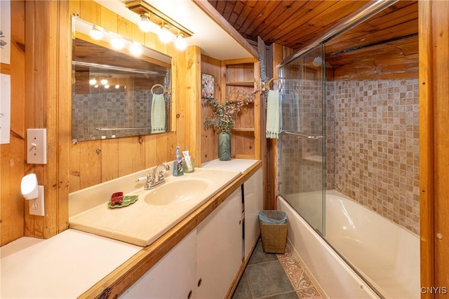 full bath with tile patterned flooring, vanity, shower / bath combination with glass door, wooden ceiling, and wood walls