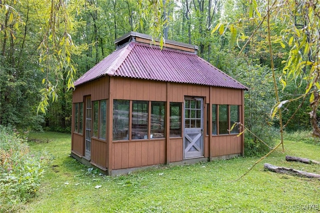 view of outdoor structure featuring a forest view and an outbuilding