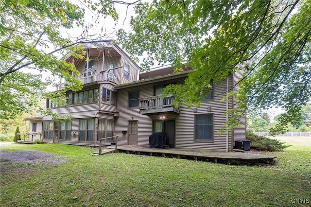 back of property with a balcony and a lawn