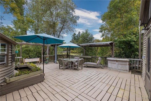 deck with outdoor dining space and a vegetable garden