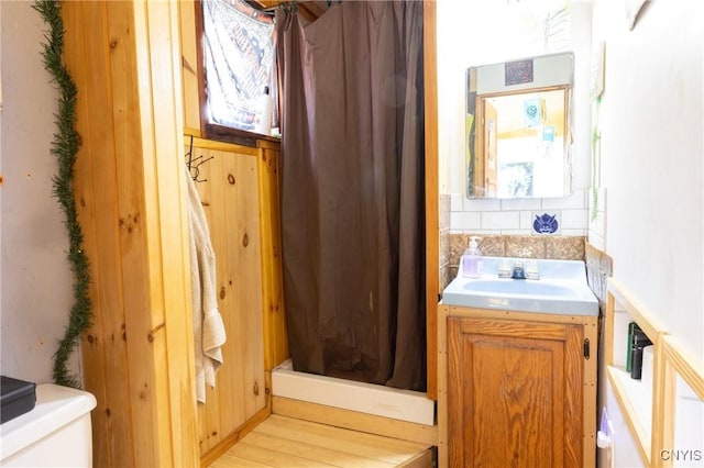 bathroom featuring vanity, curtained shower, tasteful backsplash, and toilet
