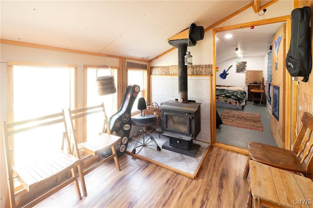 sunroom / solarium featuring vaulted ceiling and a wood stove