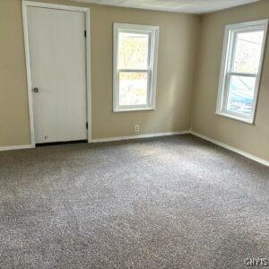 unfurnished room with plenty of natural light, carpet flooring, and baseboards