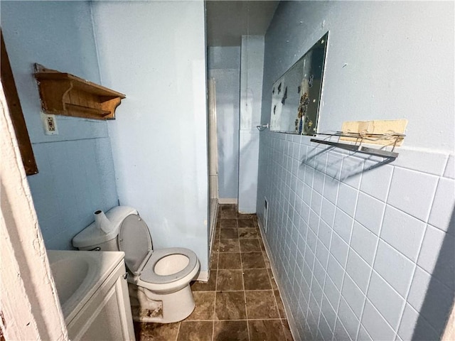 13 Brooklyn St, Rochester, NY 14613 - bathroom featuring toilet, tile walls, and tile patterned floors