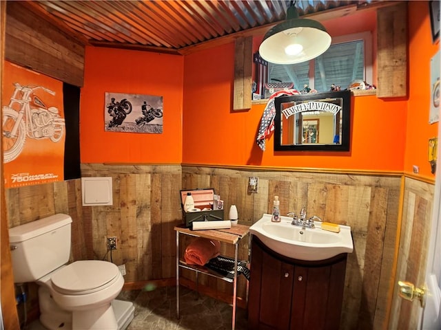 575 Harper Rd, Harpersfield, NY 13786 - half bathroom with wooden walls, wainscoting, toilet, and vanity