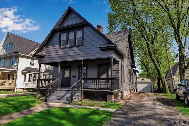 view of front of property featuring a chimney, an outdoor structure, covered porch, and a garage