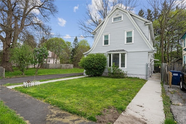 view of home's exterior featuring a gate and a gambrel roof