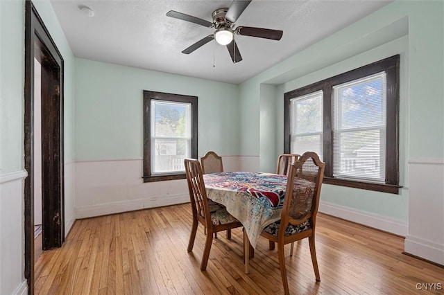 dining area featuring light wood-style flooring, baseboards, and ceiling fan