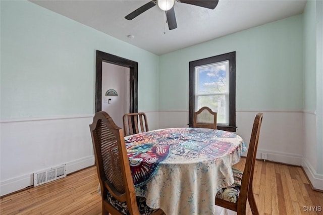 dining room with light wood finished floors, ceiling fan, and baseboards
