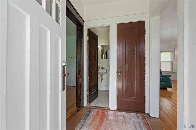 corridor with hardwood / wood-style flooring and baseboards