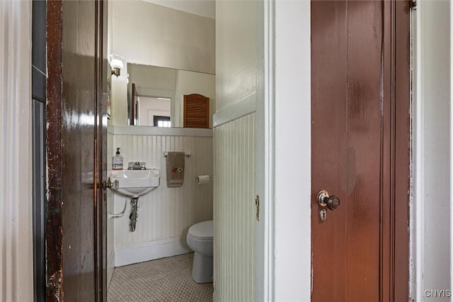 half bathroom featuring toilet and tile patterned flooring