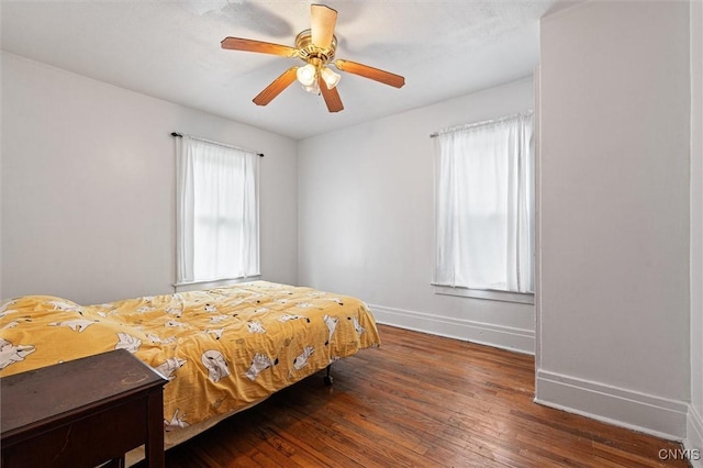 bedroom featuring baseboards, wood-type flooring, and a ceiling fan