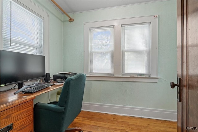 office space featuring crown molding, baseboards, and wood finished floors