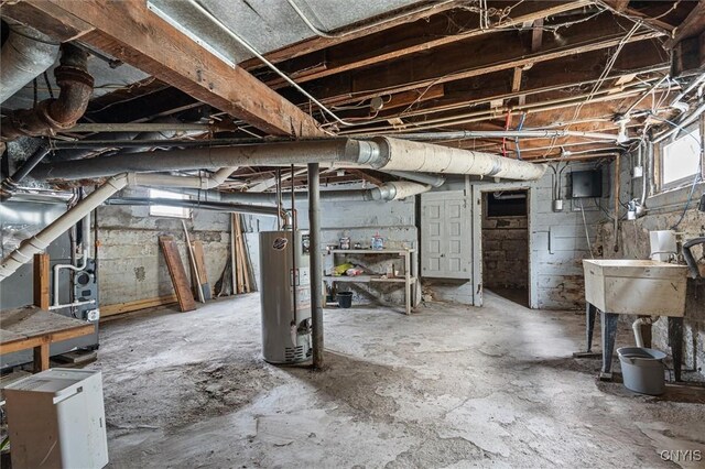 below grade area featuring gas water heater, a sink, and heating unit