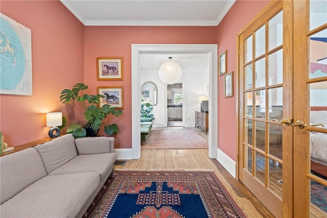 hallway featuring french doors, wood finished floors, baseboards, and crown molding