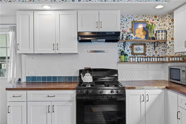 kitchen with black range with gas cooktop, under cabinet range hood, wood counters, decorative backsplash, and stainless steel microwave