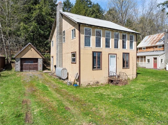 7709 State Highway 28, Exeter, NY 13439 - rear view of house featuring an outbuilding, a chimney, a detached garage, a yard, and oil tank