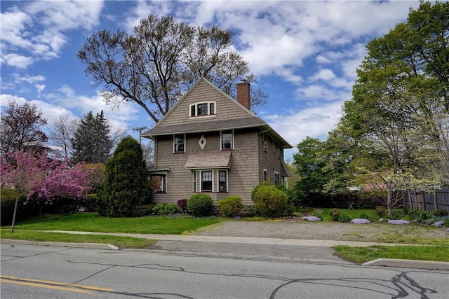 view of front of home with a chimney and a front yard