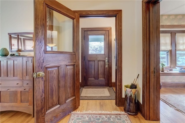 doorway to outside featuring light wood-type flooring and baseboards