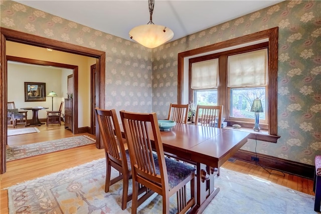 dining space featuring light wood finished floors and baseboards