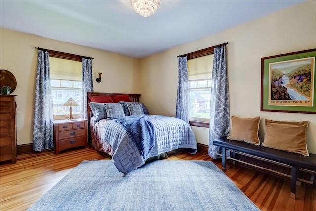 bedroom featuring multiple windows, wood finished floors, and baseboards