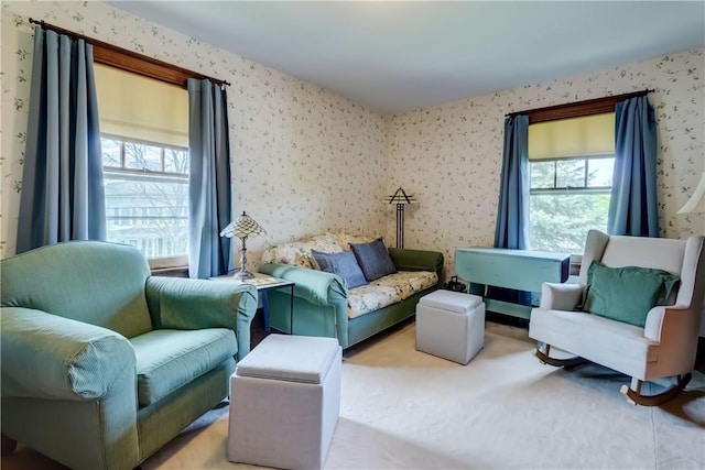 sitting room featuring wallpapered walls, healthy amount of natural light, and carpet