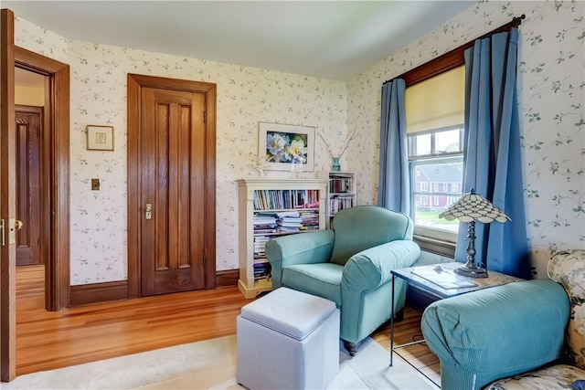 living area featuring light wood-style floors and wallpapered walls