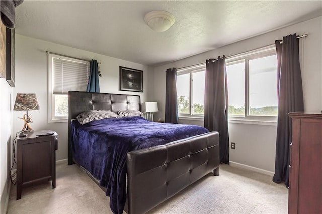 bedroom with light carpet and baseboards
