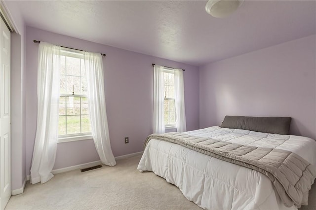 bedroom featuring baseboards and light colored carpet