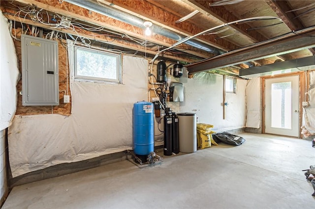 basement featuring electric panel, a water pressure tank, healthy amount of natural light, and a water softener