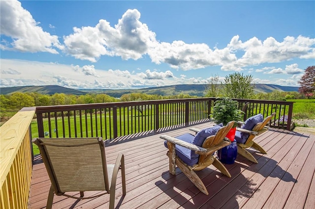 wooden terrace with a mountain view and a lawn