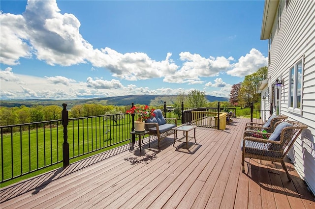 wooden deck featuring a yard and a mountain view