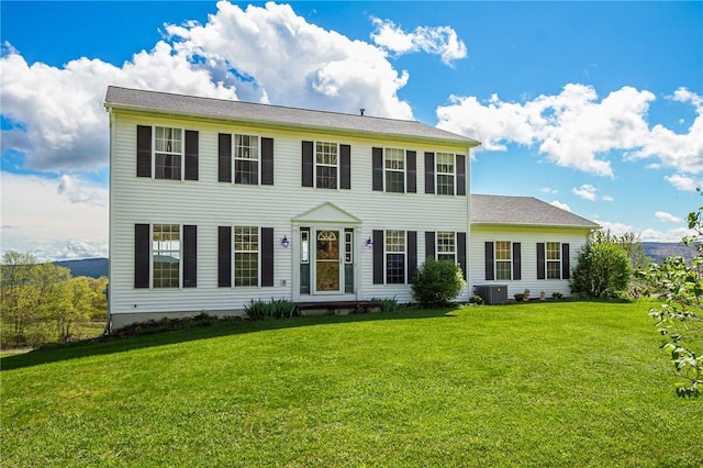 colonial inspired home with cooling unit and a front lawn