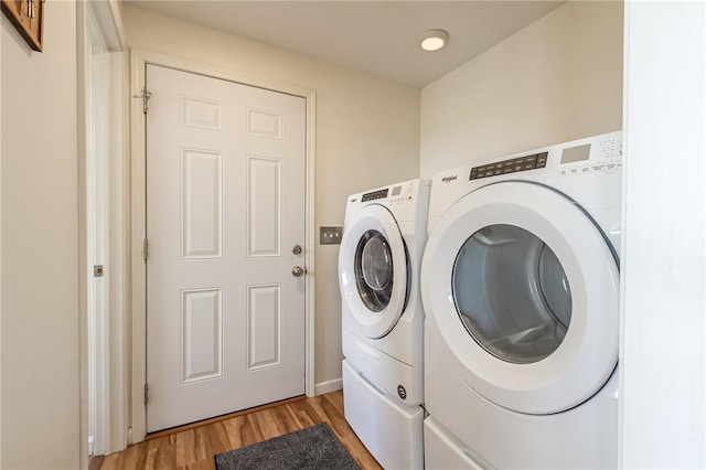 washroom featuring washer and clothes dryer and light wood-type flooring