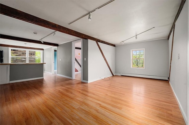 7471 State Highway 80, Springfield, NY 13326 - unfurnished living room featuring a baseboard radiator, rail lighting, healthy amount of natural light, light wood finished floors, and beamed ceiling