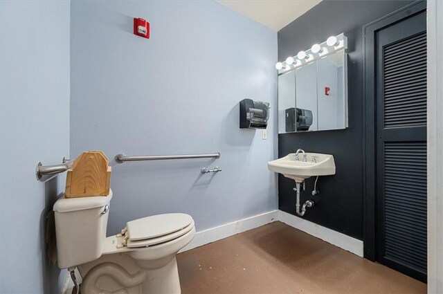 7471 State Highway 80, Springfield, NY 13326 - bathroom featuring baseboards, toilet, finished concrete flooring, and a sink