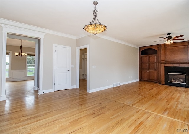 100 Brandywine Dr, Manlius, NY 13104 - unfurnished living room with a chandelier, light wood-style floors, ceiling fan, a large fireplace, and ornamental molding