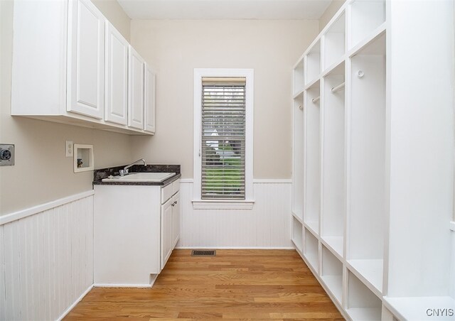 100 Brandywine Dr, Manlius, NY 13104 - washroom featuring a wainscoted wall, hookup for an electric dryer, light wood-style flooring, washer hookup, and cabinet space